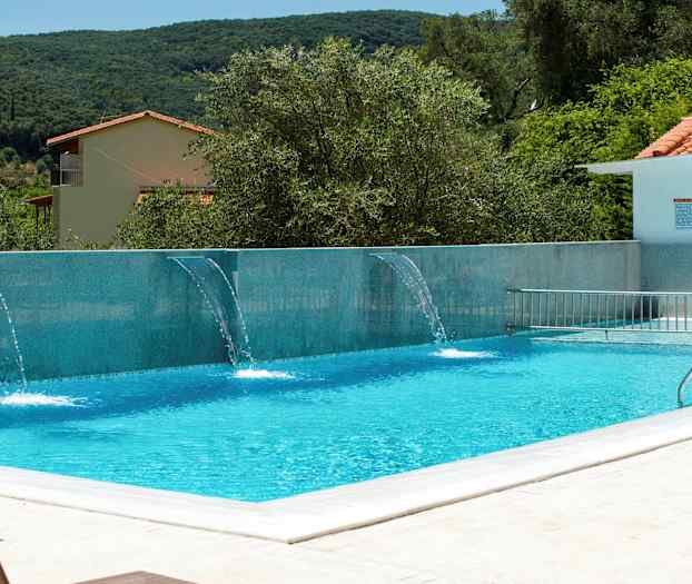 Utendørsbasseng med vannstråler og omkringliggende vegetasjon. (AI-generert tekst)