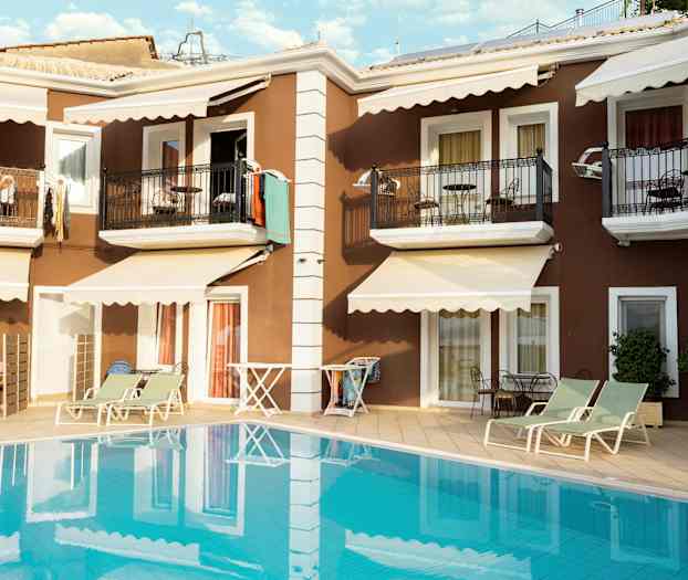 Leilighetsbygning med balkonger og solsenger ved bassenget. (AI-generert tekst)