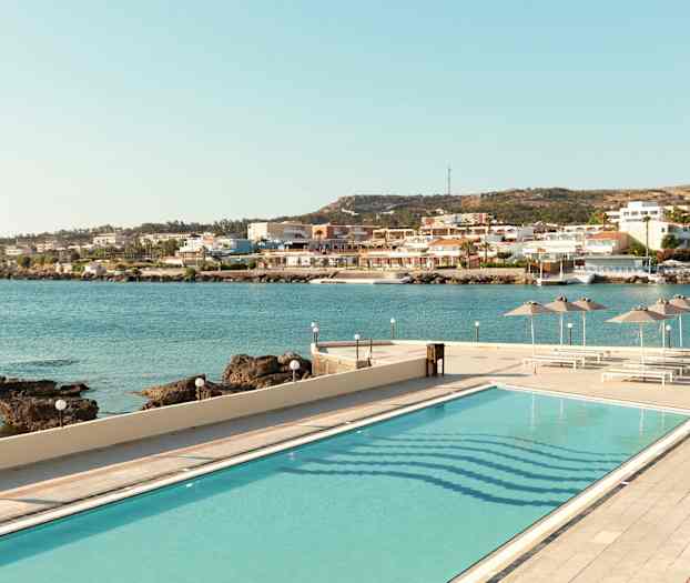 Bilde av et basseng med utsikt over havet og en kystby. (AI-generert tekst)