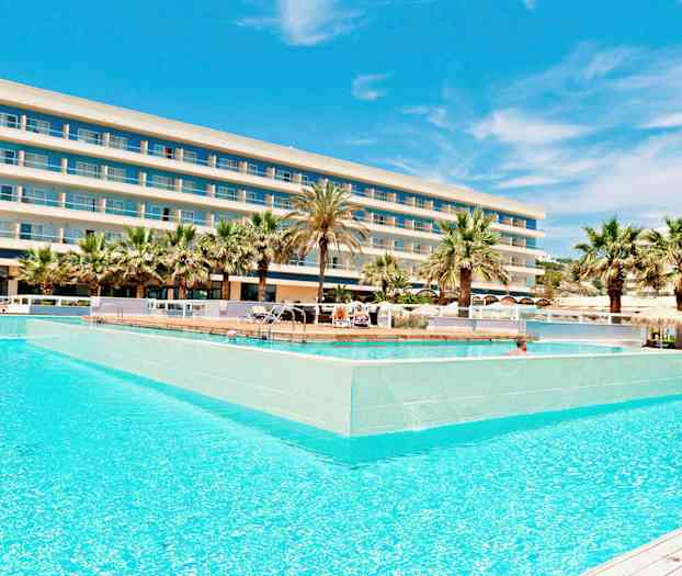 Et hotell med flere etasjer bak et stort basseng omgitt av palmer. (AI-generert tekst)