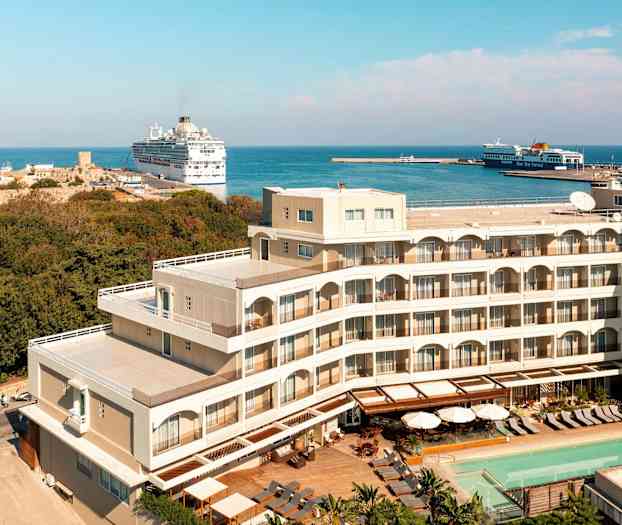 Hotellbygning nær havn og hav. (AI-generert tekst)