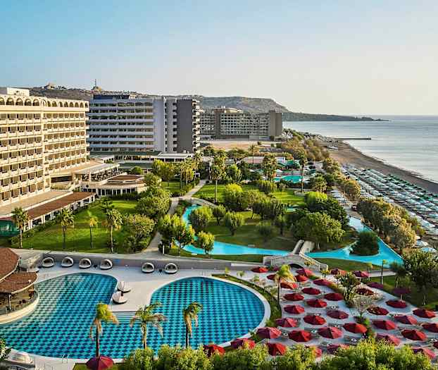 Hotellanlegg med bassenger, grøntområder og strand. (AI-generert tekst)