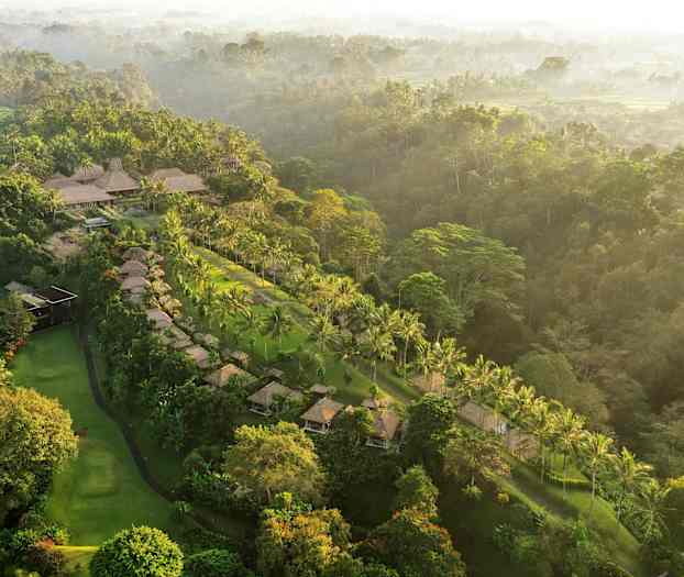 Et luftfoto av et tropisk landskap med palmer, overnattingssteder og frodig vegetasjon. (AI-generert tekst)
