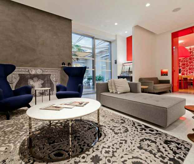 Moderne innredet stue med lenestoler, sofa og dekorativ peis. (AI-generert tekst)