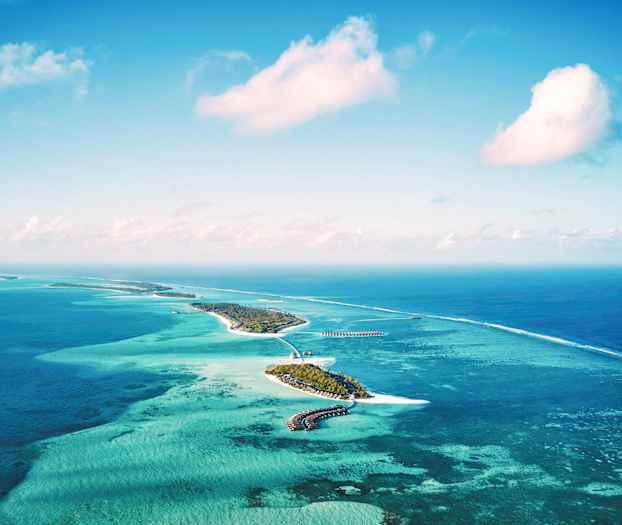 Flyfoto av tropiske øyer omgitt av turkisblått hav. (AI-generert tekst)