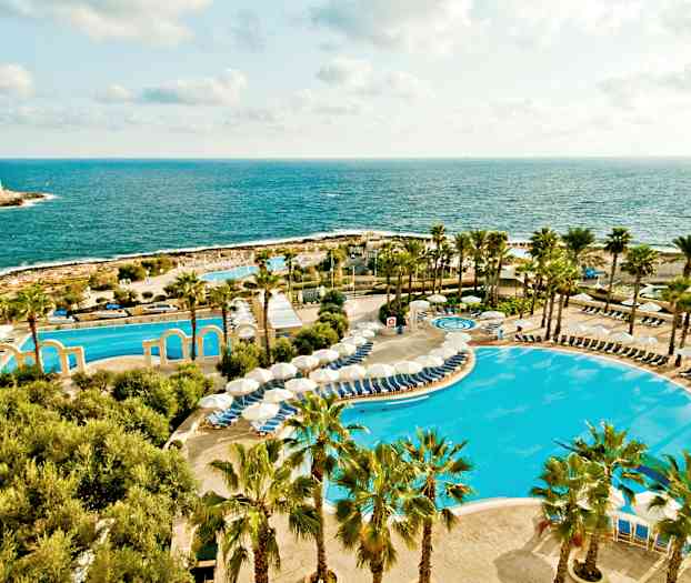 Bilde av en resort ved havet med bassenger, parasoller og palmetrær. (AI-generert tekst)