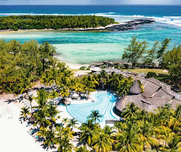 Strand og bassengområde med palmer og turkis vann. (AI-generert tekst)