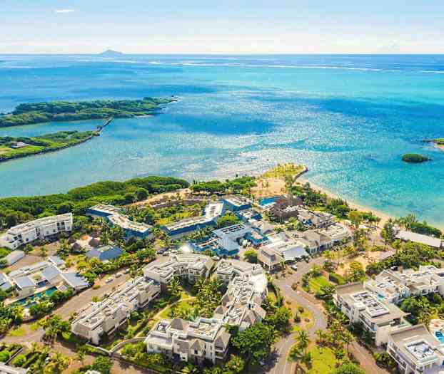 Luftfoto av et feriested ved en strand med blått hav. (AI-generert tekst)