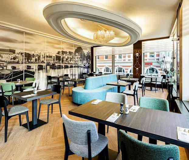 En restaurantinteriør med moderne møbler og stort fototapet av en byutsikt på veggen. (AI-generert tekst)