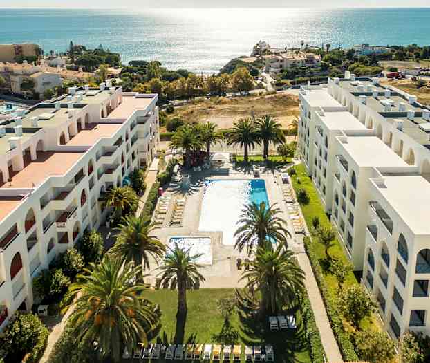 Luftfoto av hotell med bassengområde og utsikt over havet. (AI-generert tekst)