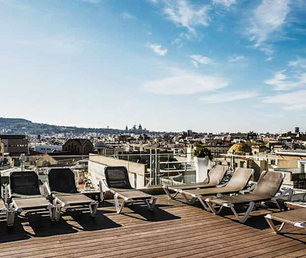 Solstoler på en takterrasse med utsikt over bymiljø. (AI-generert tekst)