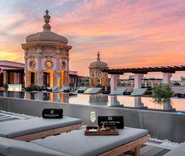 Utsikt over takbasseng med solsenger og dekorative kupler i solnedgang. (AI-generert tekst)