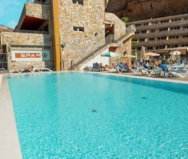 Utendørs basseng ved hotell med solsenger og parasoller. (AI-generert tekst)