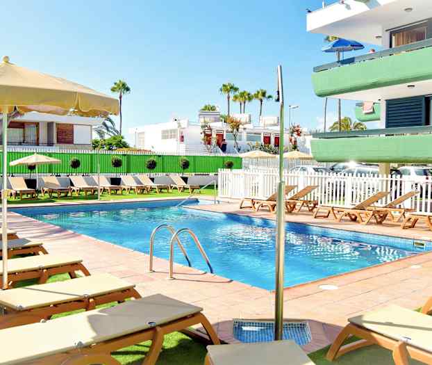 Utendørs svømmebasseng med solsenger og parasoller ved et leilighetskompleks. (AI-generert tekst)