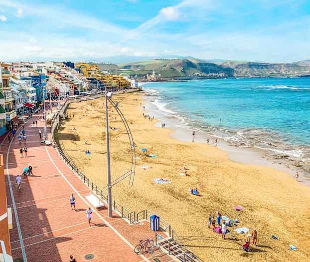 Strand med mennesker, sjø og gangvei. (AI-generert tekst)