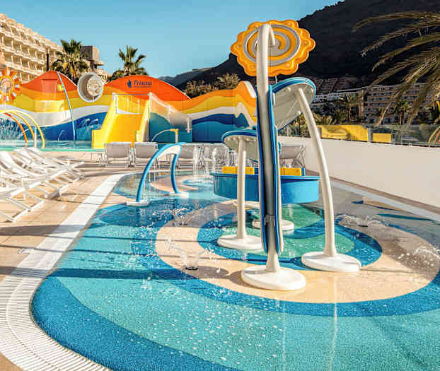 Barnebasseng med vannleker og solsenger på hotellområdet. (AI-generert tekst)