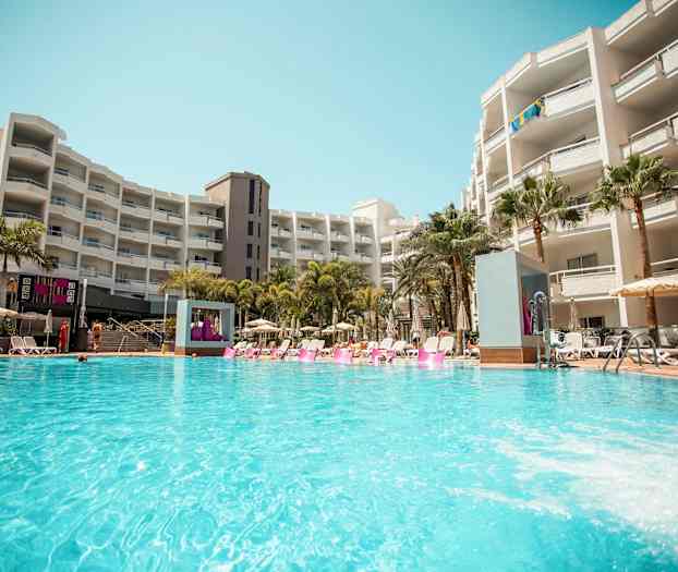 Et hotellbasseng ved et større bygningskompleks. (AI-generert tekst)