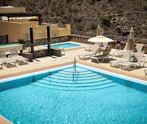 Utendørsbasseng med solsenger og parasoller ved siden. (AI-generert tekst)