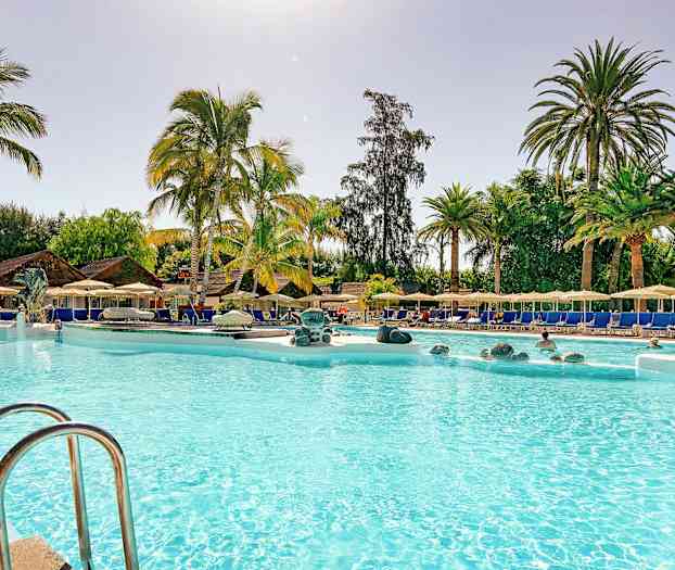 Bassengområde med palmer, solsenger og parasoller. (AI-generert tekst)