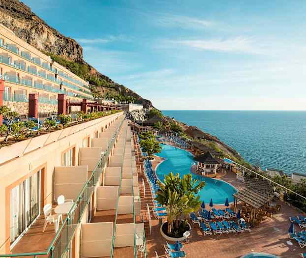 Et hotell med balkonger, svømmebassenger og havutsikt. (AI-generert tekst)