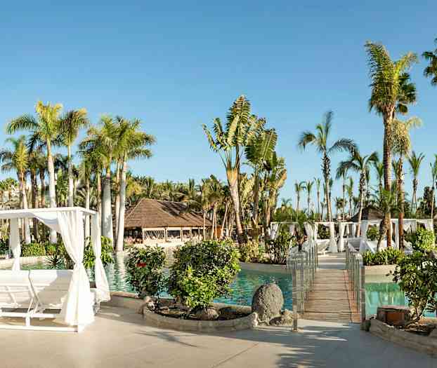 Solfylt ferieanlegg med basseng, palmer, trepergola og beplantning. (AI-generert tekst)