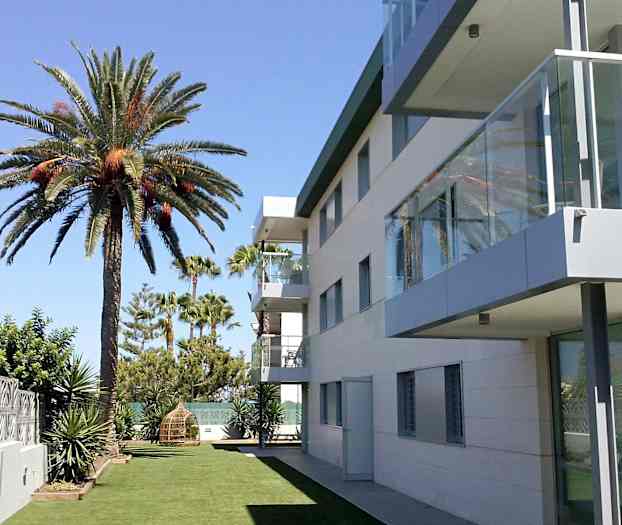 Moderne bygning ved siden av en plen med palmer. (AI-generert tekst)