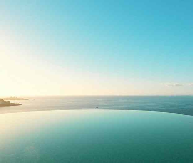 Infinitybasseng foran havutsikt. (AI-generert tekst)