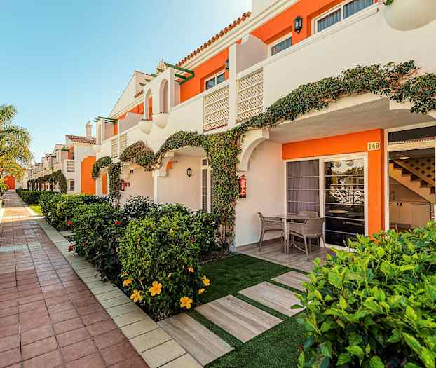 Rekke med ferieleiligheter med private terrasser og hage. (AI-generert tekst)