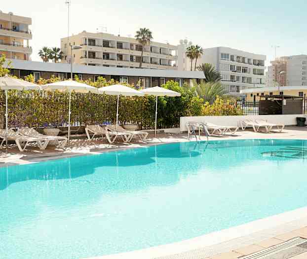 Utendørsbasseng med solsenger og parasoller ved bassengområdet. (AI-generert tekst)