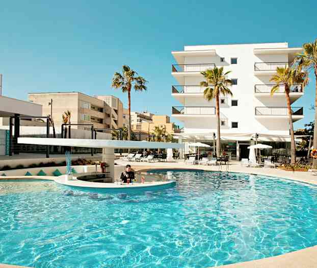 Bildet viser et utendørs basseng omgitt av palmer og solsenger, med et moderne hotell i bakgrunnen. (AI-generert tekst)