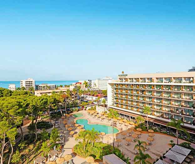 Utsikt over hotellområde med basseng, grøntområder og hav i bakgrunnen. (AI-generert tekst)