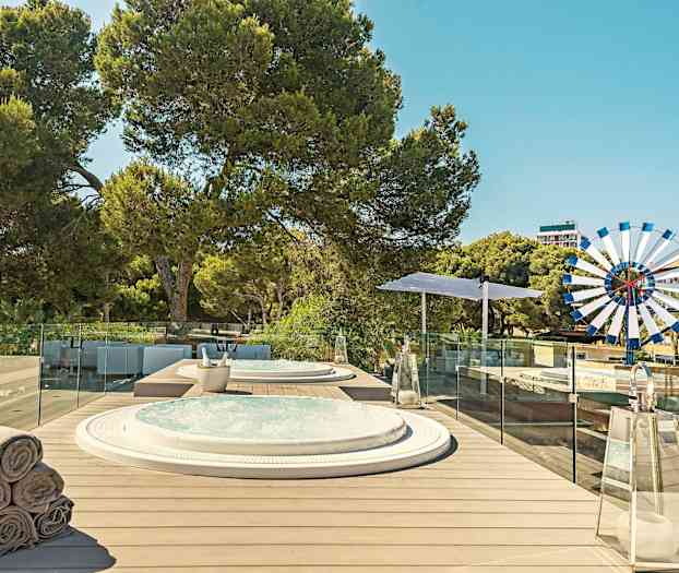 Terrasse med boblebad, solsenger og frodig vegetasjon. (AI-generert tekst)