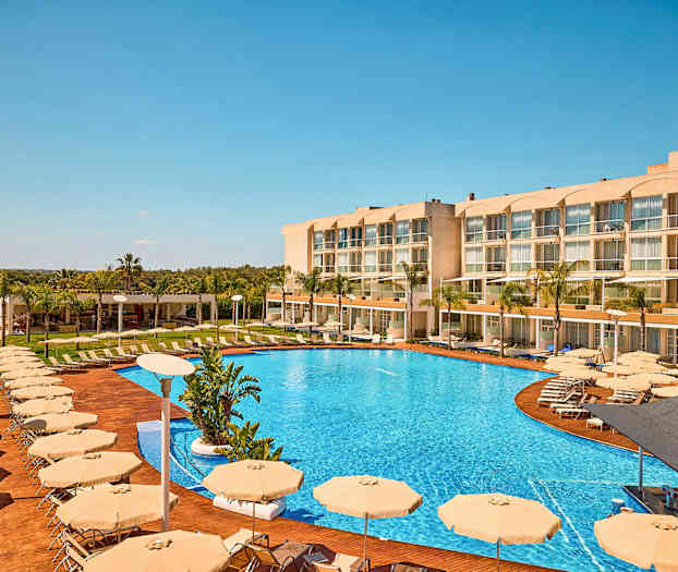 Bilde av et hotell med et stort basseng, solsenger og parasoller. (AI-generert tekst)