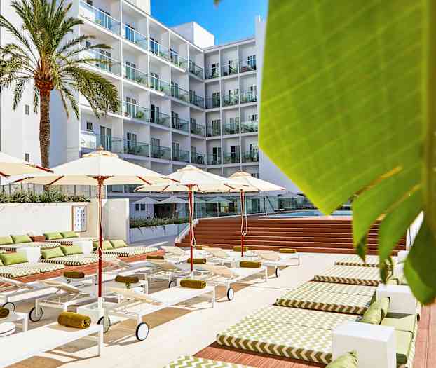 Hotellbassengområde med solsenger, parasoller og en fleretasjesbygning i bakgrunnen. (AI-generert tekst)