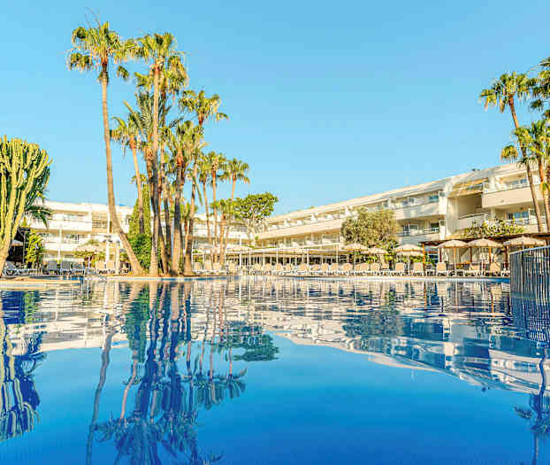 Bilde av et hotell med palmer ved et basseng. (AI-generert tekst)