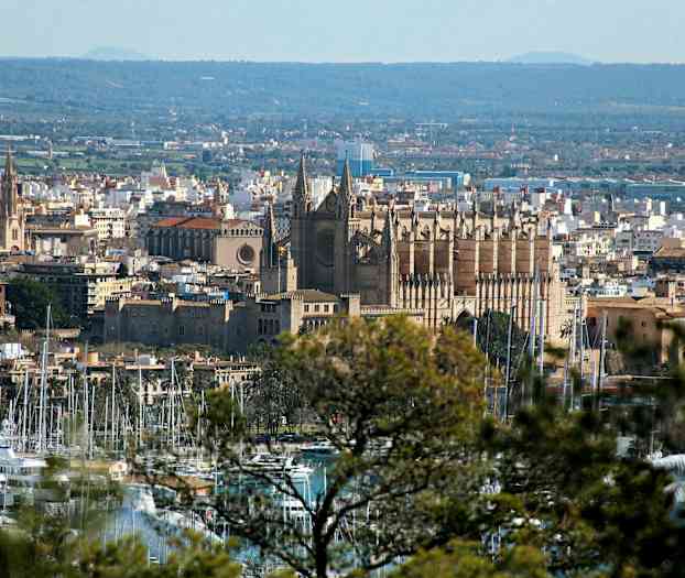 Bilde av en by med en katedral i sentrum og en marina i forgrunnen. (AI-generert tekst)