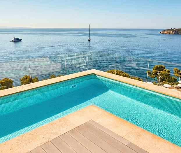 Bilde av et basseng med utsikt over havet og båter. (AI-generert tekst)