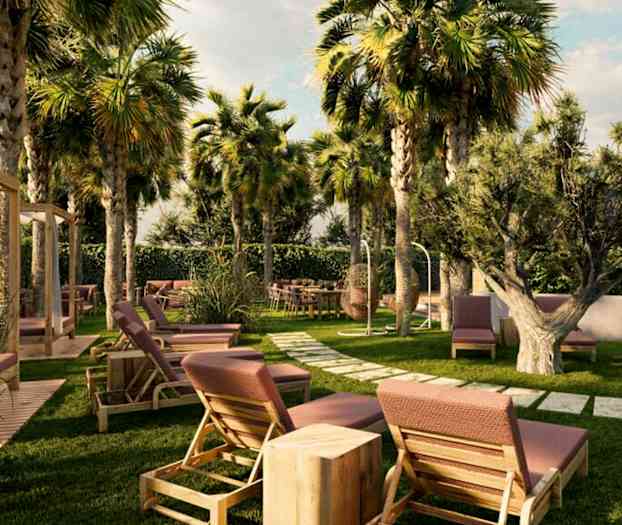 En hage med solsenger, bord og stoler blant palmer og annen vegetasjon. (AI-generert tekst)