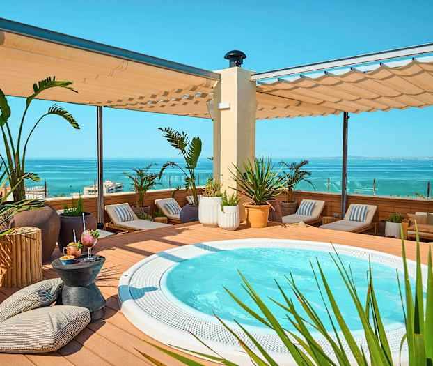 Terrasse med boblebad, solsenger og havutsikt. (AI-generert tekst)