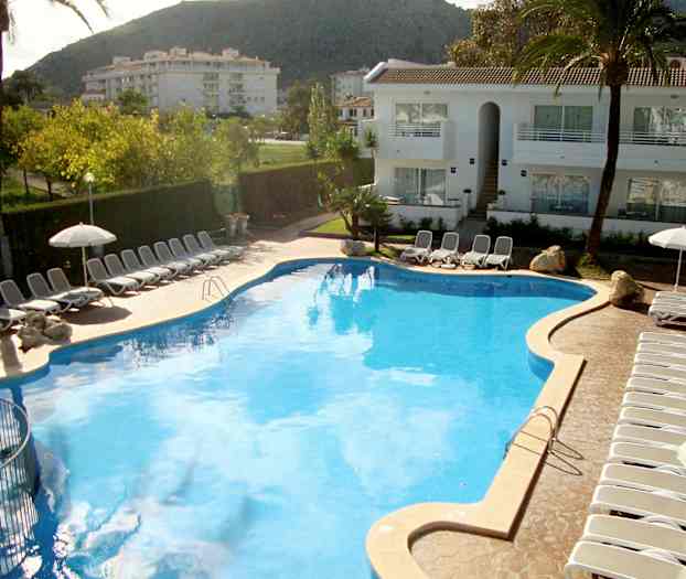 Stor basseng omgitt av solsenger og parasoller ved et hotell. (AI-generert tekst)