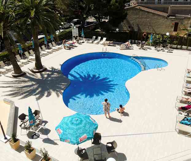 Utendørs svømmebasseng med solsenger og parasoller rundt omkring. (AI-generert tekst)