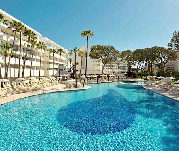 Et solfylt basseng omgitt av solsenger, parasoller og palmer ved et hotell. (AI-generert tekst)