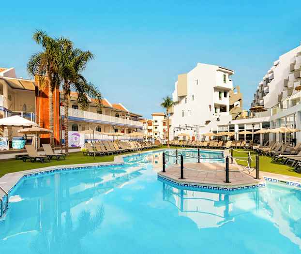 Hyggelig bassengområde på et hotell med solsenger, parasoller og omkringliggende bygninger. (AI-generert tekst)