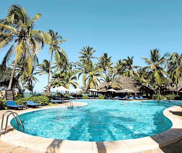 Bilde av et basseng omgitt av solsenger, parasoller og palmer med en klar blå himmel. (AI-generert tekst)