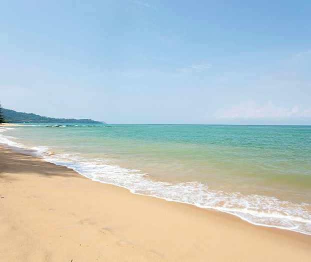Bilde av en sandstrand med havet i bakgrunnen. (AI-generert tekst)