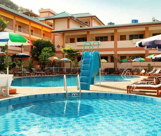 Hotellbassengområde med solsenger og parasoller. (AI-generert tekst)