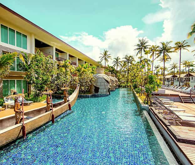 Hotellområde med svømmebasseng, omgitt av palmer og solsenger. (AI-generert tekst)