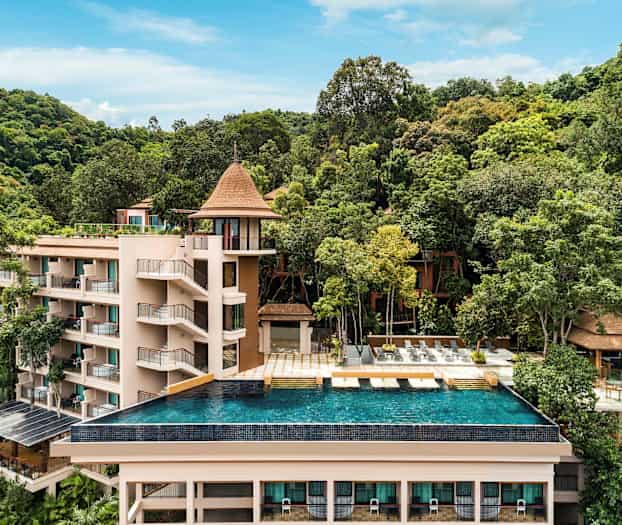 Et feriested omgitt av grøntområder med et evighetsbasseng i forgrunnen. (AI-generert tekst)