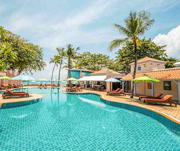 Bassengområde med parasoller og solsenger ved en ferieanlegg. (AI-generert tekst)