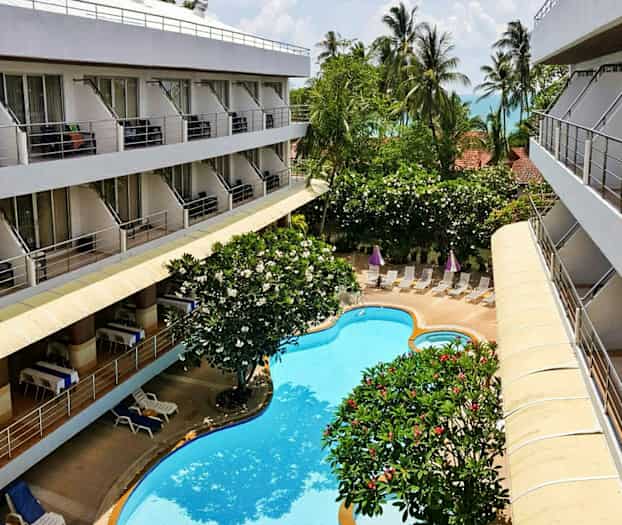 Bilde av et hotell med balkonger, hage og basseng. (AI-generert tekst)